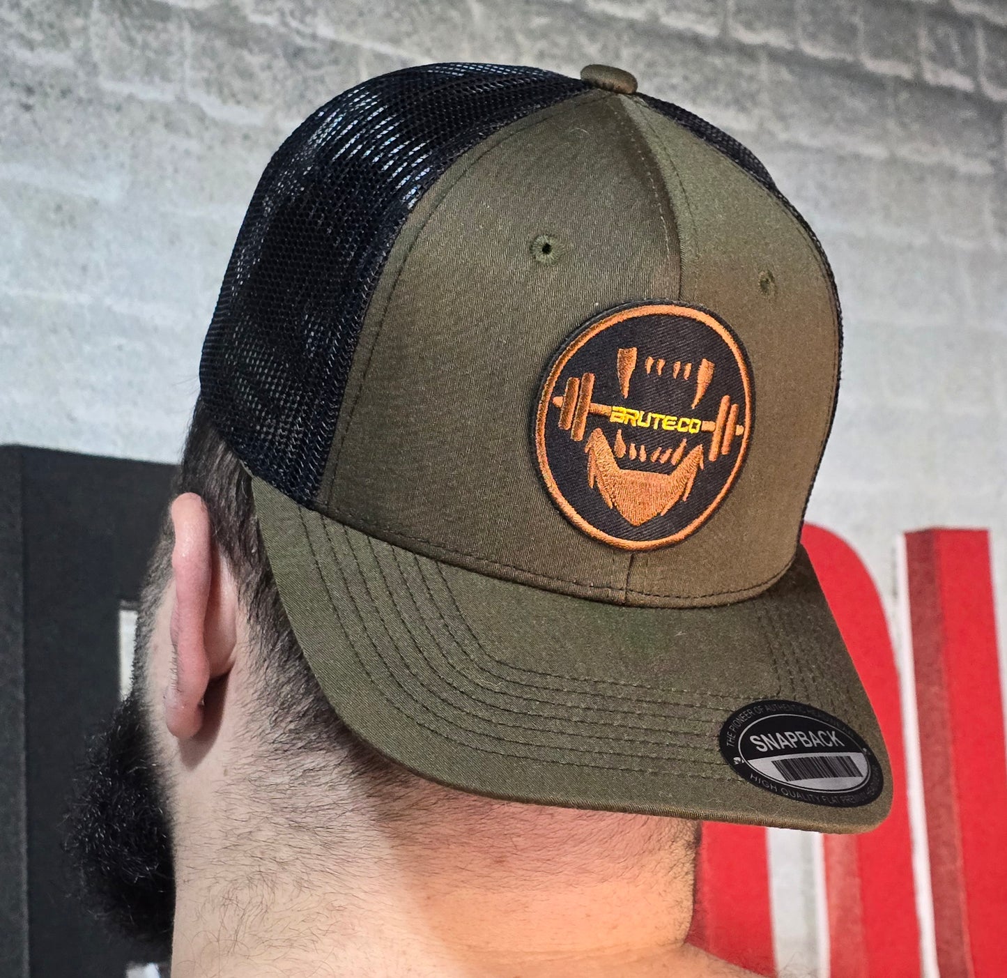 Brute Co Round Brown and Orange Logo on a Hunter Green Snapback